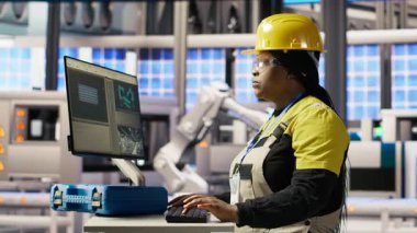 PC 'de yazan neşeli fabrika mühendisinin portresi, üretim hatlarının izlenmesini denetliyor. Endüstrideki neşeli kadın 4.0 fabrika teçhizatı optimum verimlilikte çalışıyor, kamera B