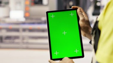 Güneş panelleri bitki teknisyeni sistemleri denetlemek için yeşil ekran tableti kullanıyor. Fotovoltaik fabrikası çalışanı işlemleri sürdürmek için krom anahtar aygıtı üzerinde yazılım kullanır, kamera B.