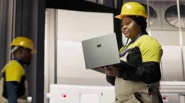 Akıllı fabrika mekanik bilgisayar operasyonları ve enerji tüketimini dizüstü bilgisayarla izlemek. Sektör 4.0 'da yürüyen tamirci. Not defteri ile tesiste. Teknik destek sağlıyor.