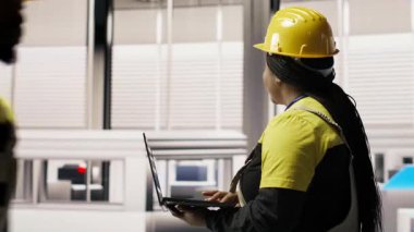 Uzman, yenilenebilir enerji üreten sanayi 4.0 fabrikasında rutin teftişler yapmak için dizüstü bilgisayar kullanıyor. Fotovoltaik teknisyeni akıllı fabrika test ekipmanları Not defteri, kamera B kullanarak