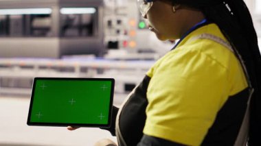 Endüstriyel fabrika teknisyeni yeşil enerji çözümleri uygulamak ve güneş teknolojisini sistemlere entegre etmek için izole edilmiş ekran tableti kullanır. Fabrika işçisi modelleme cihazı kullanarak üretim verimliliğini arttırıyor