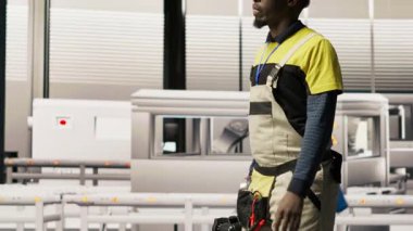 Endüstri 4.0 fabrikasında yürüyen adam, yapılması gereken değişiklikleri not alıyor, teknik destek sağlıyor. Akıllı fabrika işçisi IoT sensörleri ekliyor enerji tüketimini izliyor, kamera B