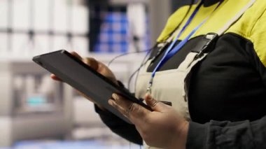 Akıllı güneş enerjisi üretim tesisinde mühendis yüksek teknoloji makinelerini ayarlıyor ve sensör verilerini analiz ediyor. Mühendis sorun çıkarma fotovoltaik montaj ekipmanı, kamera B, kapat.