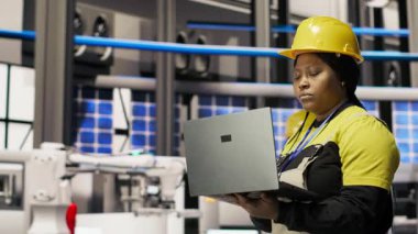 Akıllı fabrikada yürüyen mühendis, IoT sensör verilerini analiz etmek ve vites verimliliğini artırmak için dizüstü bilgisayar kullanıyor. Endüstri 4.0 bitkisel uzmanlık sistemi tanımlamaları, duraklama süresini azaltmak için kamera B