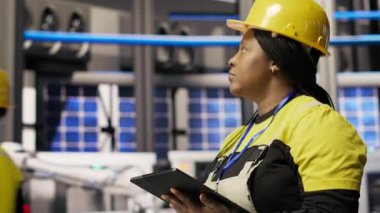 Yüksek teknoloji makinelerini ayarlamak ve sensör verilerini analiz etmek için tablet uygulamasını kullanan akıllı üretim fabrikası mühendisi. Fotovoltaik montaj ekipmanları için dijital aygıt kullanan mühendis, kamera B