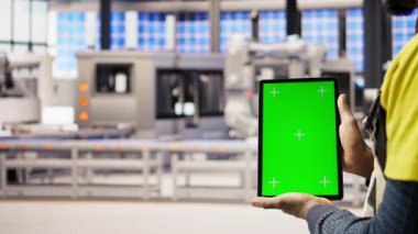 Akıllı fabrika uzmanı otomatik iş akışlarını uygulamak için yeşil ekran tableti kullanır. Endüstri 4.0 fabrika teknisyeni sensörleri krom anahtar cihazı ve kamera kullanarak üretime entegre ediyor.