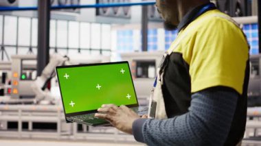 Tecrit edilmiş ekran dizüstü bilgisayar kullanarak otomatikleştirilmiş sistemleri test eden akıllı bir fabrika tamircisi. Endüstri 4.0 tesis işçisi hata tespit etmek için model not defteri kullanarak ekipmanları denetliyor, kamera A