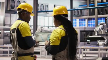 Akıllı güneş panelleri fabrika mühendisliği ekibi üretim hatlarını denetlemek için dizüstü bilgisayar kullanıyor. Takım çalışması sektörü 4.0 fabrika çalışanları, makinelerin en uygun verimlilikte çalışmasını sağlar. Not defteri, kamera A kullanarak.