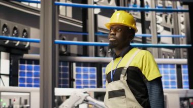 Elinde alet çantası olan bir adam fabrikada yürüyor, sistemleri denetliyor, makinelerin en uygun verimlilikte çalıştığından emin oluyor. Sanayi 4.0 fabrika tamircisi altyapıyı denetliyor, işlemleri sürdürüyor, kamera B