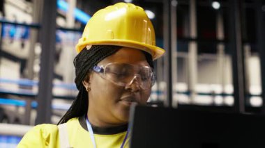 Güneş panelleri fabrika teknisyeni sistemleri denetlemek için dizüstü bilgisayar kullanır, makinelerin en uygun verimlilikte çalışmasını sağlar. Fotovoltaik fabrikası çalışanı işlemleri sürdürmek için deftere yazılım kullanıyor, kamera B