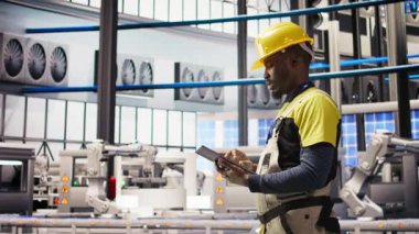 Akıllı fabrika uzmanı otomatik iş akışlarını ve kontrol sistemlerini bilgisayara aktarmak için tablet kullanır. Endüstri 4.0 fabrika teknisyeni sensörleri cihaz, kamera A kullanarak üretime entegre ediyor