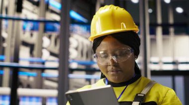 Akıllı fabrikada çalışan iyimser bir profesyonel robot üretim hatlarını denetliyor ve kalite kontrolü sağlıyor. Sanayi 4.0 bitki uzmanı otomatik taşıma sistemlerini not defteri, kamera B kullanarak izliyor