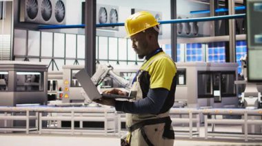 Akıllı fabrikadaki mühendis dizüstü bilgisayar yazılımı kullanarak IoT sensör verilerini analiz ediyor. Fotovoltaik sistemlerin işlevsel güvenilirliğini yöneten sanayi 4.0 fabrika işçisi not defteri, kamera A