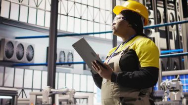 Akıllı fabrika mühendisi IoT sensör verilerini analiz etmek için tablet kullanıyor, ekipman işletim verimliliğini artırıyor. Endüstriyel fabrika işçisi üretim kesintilerini azaltmak için sistem kontrolü yapıyor, kamera A