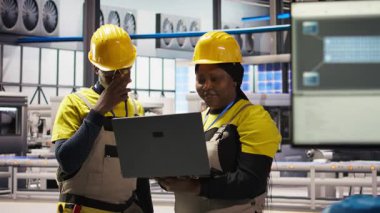 Mühendislik ekibi fotovoltaik fabrikasında birlikte çalışarak sistem performans ölçümlerine bakıyor. Sektör 4.0 'daki ekip çalışması IoT sensörleri ve kamera A aracılığıyla enerji üretimini takip ediyor.