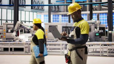 Akıllı fabrika uzmanı, otomatik sistemleri test ediyor, üretim performansını izliyor. Sanayi 4.0 fabrika teknisyeni, A kamerasının darboğazını tespit etmek ve optimize etmek için makine denetliyor.