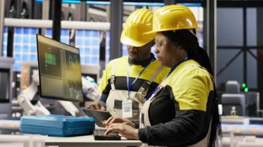 Mühendislik ekibi akıllı fabrikada bilgisayar kullanarak robot montaj hatlarını denetliyor ve imalat sırasında kalite kontrolü sağlıyor. Takım çalışma arkadaşları otomatik taşıma bantlarını, kamera B 'yi izliyor.