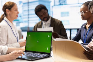 Yatırımcı grubu, potansiyel iş genişletme planlarını tartışmak üzere Chroma Key Screen ile bir toplantıda bir araya geldi. Başka bir yatırım ve şirket brifingi için raporları inceliyorum..