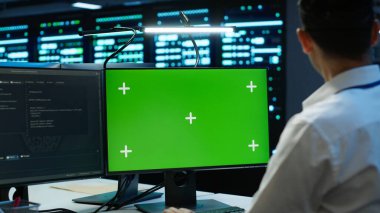 Veri merkezinde Chroma Key PC ile çalışan mühendis dişli enerji tüketimini yönetmek için kullanılır. Sunucu çiftliği, kamera A 'da otomasyon için kullanılan çalışma alanındaki izole ekran monitörünü kullanan çalışan