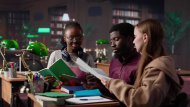 Üniversite öğrencileri kampüs kütüphanesinde uluslararası işletme yönetimi ve yönetimine odaklanarak başlangıç projesinde işbirliği yapıyorlar. Akademik diplomaları için çok çalışıyorlar. Kamera A.