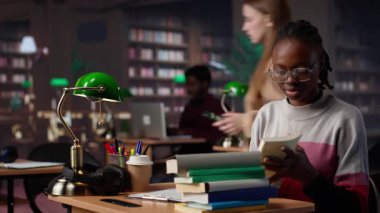 Afrikalı Amerikalı bir kız kampüs kütüphanesindeki veritabanını kullanarak celpler ve diğer bilgiler için bekar kağıdı araştırması yapıyor. Diploması üzerinde çalışan zeki bir öğrenci. Kamera A.