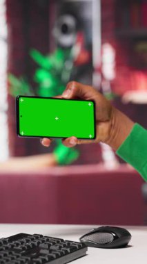 Dikey Video Afrikalı Amerikalı adam kroma anahtarın yanında yapay zeka sohbet robotu ile meşgul, sanal asistanı kullanarak veri güdümlü algoritmalar kullanarak ev ofisindeki veriyi arttırıyor. Kamera A.