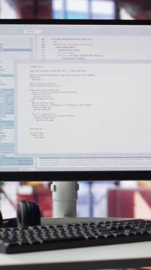 Bilgisayarlı dikey video ofis, programlama kodu için terminal penceresi çalışıyor. IT profesyonelleri için tasarlanan alan, kullanıcı arayüzü, hata ayıklama ve algoritma betikleri üzerinde çalışmak için konfor sunuyor.