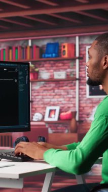 Evdeki dikey videolu Afrikalı Amerikalı adam yapay zeka aracıyla bilgi üretmek için yazıcı kullanıcısı tarafından yazılan yapay sohbet robotu asistanına sorular soruyor. Makine öğrenimi. Kamera.