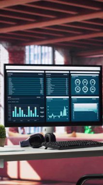 Masaüstü bilgisayar monitörlü, iş analizlerini ve pazarlama bilgi grafiklerini gösteren dikey video modern ofis, temiz minimalist masa kurulumu. Parlak stil tavan arası trend bir profesyonel sunuyor