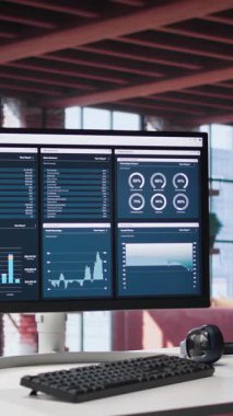 Ahşap masa başındaki Dikey Video Masaüstü Bilgisayarı bilgi grafiklerini gösterir ve istemci profesyonel kullanım için veriye ulaşır, görüntüde analitikler vardır. Parlak lüks bir çatı katında şık ve düzenli bir çalışma alanı..