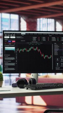 Çevrimiçi hisse senedi ticareti ve ön x analizi için PC monitörlü dikey video modern ev. Lüks tavan arası mobilyaları ve finansal grafikleri olan bir bilgisayarı harmanlıyor..