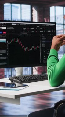 Dikey Video Günü tüccarı, iyi performans gösterebilecek hisseleri almak ve değeri düşebilecek hisseleri satmak için bilgisayarı kullanır. Eski tüccar PC masasında hisse senedi portföy sayfalarına göz atıyor