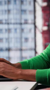 Vertical Video Young uzaktan kumandalı çalışanı, yaratıcılığını ve yeniliğini kullanarak para kazanmak için yeni fikirler üzerinde kafa yoruyor. Yeni parlak fikirler arayan Afrikalı Amerikalı bir adam. Kamera A