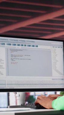 Dikey Görüntü Teknolojisi uzmanı siyah mühendis evde güvenli bir program geliştiriyor. İkili verilerle çevrili olan serbest çalışan arayüz tasarımı, senaryo optimizasyonları ve ağ sistemleri üzerinde çalışıyor. Kamera A.