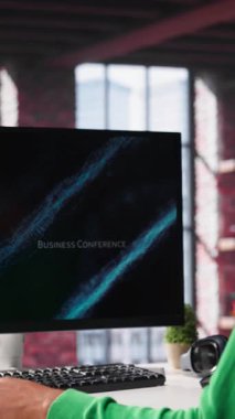 Dikey Video Siyah Serbest Çalışan PC monitöründeki iş konferansını izleyip istatistik tablolarına bakıyor. Apartman ofisindeki uzaktan çalışan bilgisayardaki sunum grafiklerini takip ediyor. Kamera A.