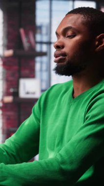 Dikey Video Afrikalı Amerikalı erkek tele-işçi dizüstü bilgisayarla hesap tablolarını tamamlıyor, hücrelere sayısal verileri giriyor ve toplamları hesaplıyor. Yazılım işlevlerini kullanan bir adam. Kamera A.