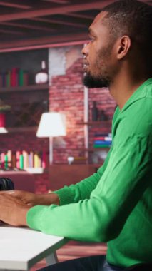 Dikey Video Siyah 'ın modern çatı katında yapay zeka sohbet yazılımını görüntülemek için kullandığı metin. Dijital ekran nöral ağlar aracılığıyla üretken içeriği gösterir, öngörü modellerini ve görselleştirilmiş verileri geliştirir. Kamera B