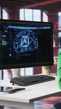 Dikey Video Afrikalı Amerikalı bilişim uzmanı yapay zeka sinir ağları üzerinde bakım yapıyor, terminal penceresine kod yazıyor. Erkek teknik destek mühendisi yapay zeka sistemlerini kontrol ediyor. Kamera.