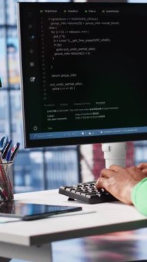 Dikey Video Afrikalı Amerikalı yazılım geliştiricisi görsel kodlama yapıyor ve yazılım yaratıyor, algoritmalar uyguluyor. Evde notlar ağaç ve kod dili, uygulama performansı ile çalışan bilişim uzmanı