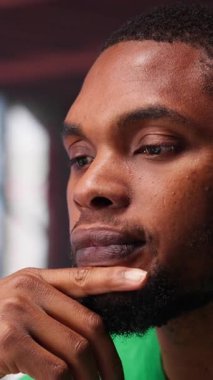 Dikey Video Afrikalı Amerikalı adam müşteri sayısını arttırmak için yeni fikirler düşünüyor, finansal büyüme için bir çözüm bulmak için birden fazla iş yapıyor. Genç uzaktan kumandalı işçi yaratıcılığını kullanıyor. Kamera A.