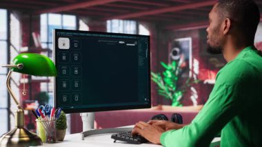 Çağdaş dairesinde yapay zeka sohbet yazılımını görüntülemek için mesaj kullanan siyahi bir adam. Dijital ekran nöral ağlar aracılığıyla üretken içeriği gösterir, öngörü modellerini ve görselleştirilmiş verileri geliştirir. Kamera A.