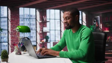 Afrika kökenli Amerikalı uzaktan kumandalı işçi, bilgisayardaki günlük serbest çalışma işlerini hallediyor, modern dairesinin rahatlığı için rahatça çalışıyor. Teknolojiden anlayan siyah adam internet kullanıcısı, birden fazla iş yapıyor. Kamera B.