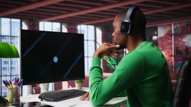 Ofiste telgraf işçisi PC 'deki iş konferansını izliyor, istatistik tablolarına bakıyor. Afrika kökenli Amerikalı uzaktan kumandalı bir çalışan bilgisayardaki sunum grafiklerine bakıyor. Kamera B.