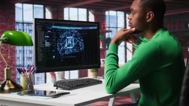 Afro-amerikan bilişim uzmanı yapay zeka sinir ağları üzerinde bakım yapıyor, terminal penceresine kod yazıyor. Erkek teknik destek mühendisi yapay zeka sistemlerini kontrol ediyor. Kamera B.