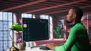 Afro-Amerikalı kişi, ev ofisinde video montajı yapmak için yapay zeka sohbet robotu kullanıyor. Kişiselleştirilmiş bir proje için derin öğrenme modelleri ve bulut teknolojisi. Metinden videoya. Kamera B.