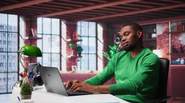 Afrika kökenli Amerikalı tele-işçi, masa başında otururken kas krampları ve ofis sendromlarıyla ilgilendiği için sırt ağrısı çekiyor. Genç adam kendini çok yorgun hissediyor. Kamera B.