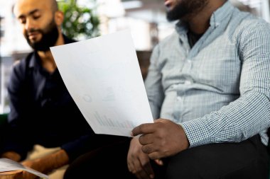 Ofis memurlarından oluşan çeşitli ekip ofisteki belgelerin gelir rakamlarını inceliyor. Şirket istatistiksel numaralarını karşılaştıran çok ırklı personel, son teslim tarihinden önce işi bitirmek için çok çalışıyor