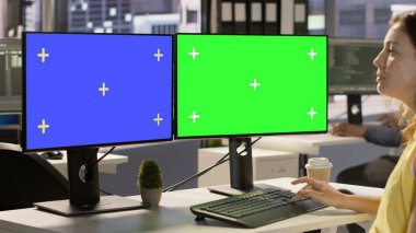 Çalışan verileri analiz etmek, muhasebe rakamlarını karşılaştırmak için çoklu monitör izole edilmiş bilgisayar kullanıyor. Takım projesi için görevleri çözmek için krom anahtar kullanan kadın, kamera A