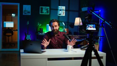 Medya yıldızı, yapımcı ekipmanlarıyla birlikte geceleri RGB ışıklarıyla aydınlatılan video kaydını yaparken kendinden bahsediyor. Profesyonel mikrofonla konuşan şovmen, kamera B
