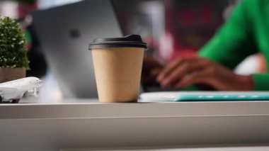 Serbest çalışan, kahve içen ve günlük ödevlerini evde yapan bir erkek, serbest olarak çalışıyor. Siyahi adam birden fazla iş yapıyor ve e-postalarına cevap veriyor, modern çatı katından yaşam tarzı. Kamera A.